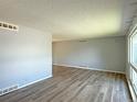Spacious living room with hardwood floors, neutral paint, and large window with ample natural light at 1822 Ura Ln, Northglenn, CO 80234