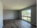 Bright living room showcasing sleek hardwood floors and a large window offering ample natural light at 1822 Ura Ln, Northglenn, CO 80234