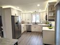 Well-lit kitchen with white cabinets, stainless steel appliances, and subway tile backsplash at 21 Douglas N Dr, Broomfield, CO 80020