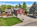 Aerial view of split-level home with well-kept lawn, mature trees, and attached two-car garage at 8065 W Fremont Dr, Littleton, CO 80128