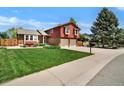 Beautiful split-level home with a well-manicured lawn, mature tree, and an attached two-car garage at 8065 W Fremont Dr, Littleton, CO 80128