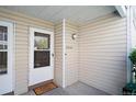 Inviting front entrance with a white door and 'Home Sweet Home' doormat with beige siding at 13635 E Yale Ave # D, Aurora, CO 80014