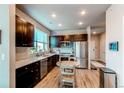 Bright kitchen with stainless steel appliances, dark cabinets, and a round dining table at 155 S Monaco Street Pkwy # 311, Denver, CO 80224