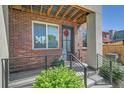 Charming front porch with brick accents, stylish door, and well-maintained landscaping for welcoming curb appeal at 7035 E 38Th Ave # 4, Denver, CO 80207