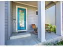Inviting front porch features a vibrant blue door flanked by rocking chairs and classic white columns at 6632 Osage St, Denver, CO 80221
