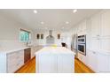Modern kitchen featuring stainless steel appliances, white cabinetry, and a central island at 14652 Kalamath Ct, Westminster, CO 80023