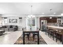 Bright dining room featuring a long wooden table, modern chandelier, and sliding glass doors for outdoor access at 6018 Beeler Ct, Denver, CO 80238