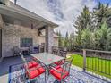 Outdoor dining area with a table, chairs, and a blue patterned rug at 4704 W Hinsdale Ct, Littleton, CO 80128