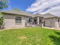 Spacious backyard with lush green lawn, stone facade, and an inviting deck at 4704 W Hinsdale Ct, Littleton, CO 80128