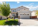 Charming two-story home featuring a covered porch, manicured lawn, and a two-car garage at 15131 Munich Ave, Parker, CO 80134