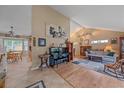 Bright living room featuring vaulted ceilings, hardwood floors, a piano, and an open layout at 8116 W Fremont Dr, Littleton, CO 80128
