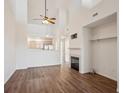 Bright living room with a ceiling fan, fireplace, and open access to the kitchen at 5800 Tower Rd # 908, Denver, CO 80249