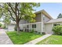 Charming two-story home with green lawn, mature tree, and convenient sidewalk access on a sunny day at 1250 S Monaco Pkwy # 50, Denver, CO 80224