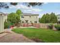 Spacious backyard featuring a wooden deck, lush lawn, mature trees, and a privacy fence at 2427 Cherry Cir, Brighton, CO 80601