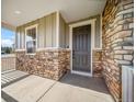 Inviting front porch featuring stone accents and a stylish entrance door at 42400 Forest Oaks Dr, Elizabeth, CO 80107