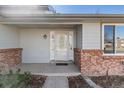 Close-up of the home's front entrance featuring a decorative glass door and brick columns at 12070 E Arizona Ave, Aurora, CO 80012