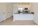 A well-lit kitchen featuring stainless steel appliances, white cabinetry, an island and light wood flooring at 14578 W 90Th Ln # B, Arvada, CO 80005
