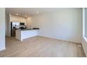 Bright kitchen features modern appliances, a center island with sleek countertops and light wood floors at 14578 W 90Th Ln # B, Arvada, CO 80005