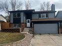 Charming two-story home with gray siding, brick accents, attached garage, and freshly landscaped front yard at 20328 E Powers Ln, Aurora, CO 80015