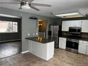 Bright eat-in kitchen features stainless appliances, white cabinetry, tile backsplash, and adjacent living area at 20328 E Powers Ln, Aurora, CO 80015
