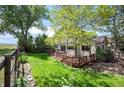 Backyard view shows a tiered wood deck, mature landscaping, and view of neighboring open space at 7582 Powderhorn Dr, Lone Tree, CO 80124