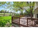 Spacious wooden deck overlooks a lush backyard and beautiful open space with mature trees at 7582 Powderhorn Dr, Lone Tree, CO 80124