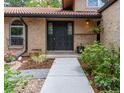 The front entrance features a solid dark door with decorative glass panes and beautiful, mature landscaping at 8793 E Monmouth Pl, Denver, CO 80237