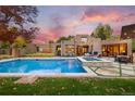 Stunning backyard with a large swimming pool, hot tub, patio with fireplace, and an outdoor dining area at 9 Polo Field Ln, Denver, CO 80209