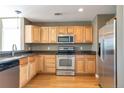 Updated kitchen with stainless steel appliances, sleek countertops, and light wood cabinets at 8751 Pearl St # D1, Thornton, CO 80229