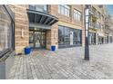 Exterior view of the building entrance with brick facade, blue planters, and paved walkway at 7220 W Bonfils Ln # 206, Lakewood, CO 80226