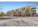 Multi-story building exterior with brick facade, balconies, and courtyard with decorative art at 7220 W Bonfils Ln # 206, Lakewood, CO 80226