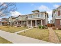 Beautiful two-story home with covered porch, brick accents, and well-kept lawn at 631 E Hinsdale Ave, Littleton, CO 80122