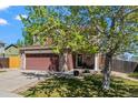 Charming two-story home featuring a two-car garage and manicured lawn in a suburban neighborhood at 13884 Lilac St, Thornton, CO 80602