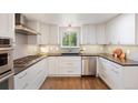Bright kitchen features white cabinets, stainless steel appliances, and hardwood floors at 6213 S Galena Way, Englewood, CO 80111