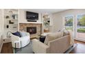 Cozy living room featuring a brick fireplace and built-in shelving at 6213 S Galena Way, Englewood, CO 80111