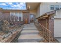 Well-maintained front entrance with brick accents and a concrete staircase, plus an ornate railing at 8690 E Chenango Ave, Denver, CO 80237