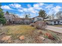 Home with a front lawn featuring xeriscaping with some mature landscaping at 8690 E Chenango Ave, Denver, CO 80237
