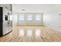 Spacious living area featuring hardwood floors, bright white walls, and large windows for plenty of natural light at 2835 W Parkside Pl # 305, Denver, CO 80221