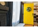 Charming entryway with a bright yellow door adorned with a wreath and a glimpse into the modern kitchen at 19044 E 16Th Ave, Aurora, CO 80011
