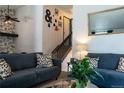 Cozy living room features stylish decor, comfortable seating, and bright natural light from the stairway entrance at 19044 E 16Th Ave, Aurora, CO 80011