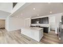 Modern kitchen with quartz countertops, a large island, stainless steel appliances, and hardwood floors at 39877 Floyd St, Elizabeth, CO 80107