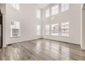 Bright living room featuring wood floors, tall ceilings, large windows, and natural light at 39877 Floyd St, Elizabeth, CO 80107