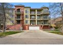 Multi-story condo showcasing private garages, balconies, and distinct brick and stucco design elements at 1705 Gaylord St # 201, Denver, CO 80206