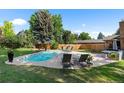 Backyard pool area with lounge chairs, patio furniture, and lush landscaping, creating a perfect relaxation space at 7830 W Friend Pl, Littleton, CO 80128