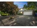 Charming two-story home featuring a well-manicured lawn, mature trees, and a spacious driveway at 4474 S Vrain St, Denver, CO 80236