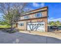 Two-story home featuring an attached two-car garage, a spacious driveway, and mature trees at 6360 S Gibraltar Cir, Centennial, CO 80016