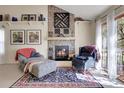 Cozy living room featuring a stone fireplace, comfortable seating, and natural light at 6360 S Gibraltar Cir, Centennial, CO 80016