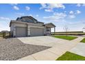 Stylish home with a two-car garage, a long driveway, and well-maintained landscaping on a sunny day at 14366 Heritage Dr, Mead, CO 80504