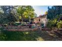 Expansive backyard with lush greenery, mature trees, and a charming stone retaining wall that offers privacy and tranquility at 5904 Meadowbrook Dr, Morrison, CO 80465