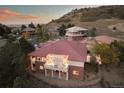 A captivating aerial view showing a well-maintained home with a tile roof and a covered patio against a hillside backdrop at 6321 Spotted Fawn Run, Littleton, CO 80125